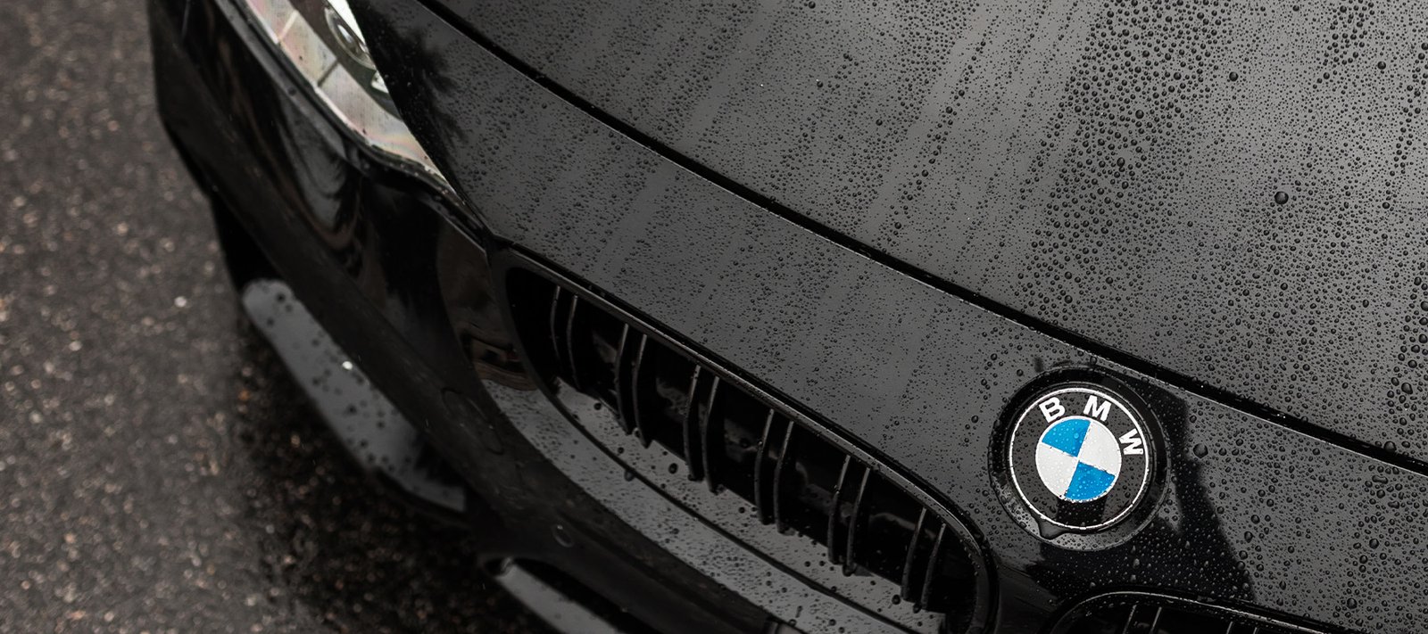 Close-up of a technician's hands tucking Paint Protection Film around a wheel arch